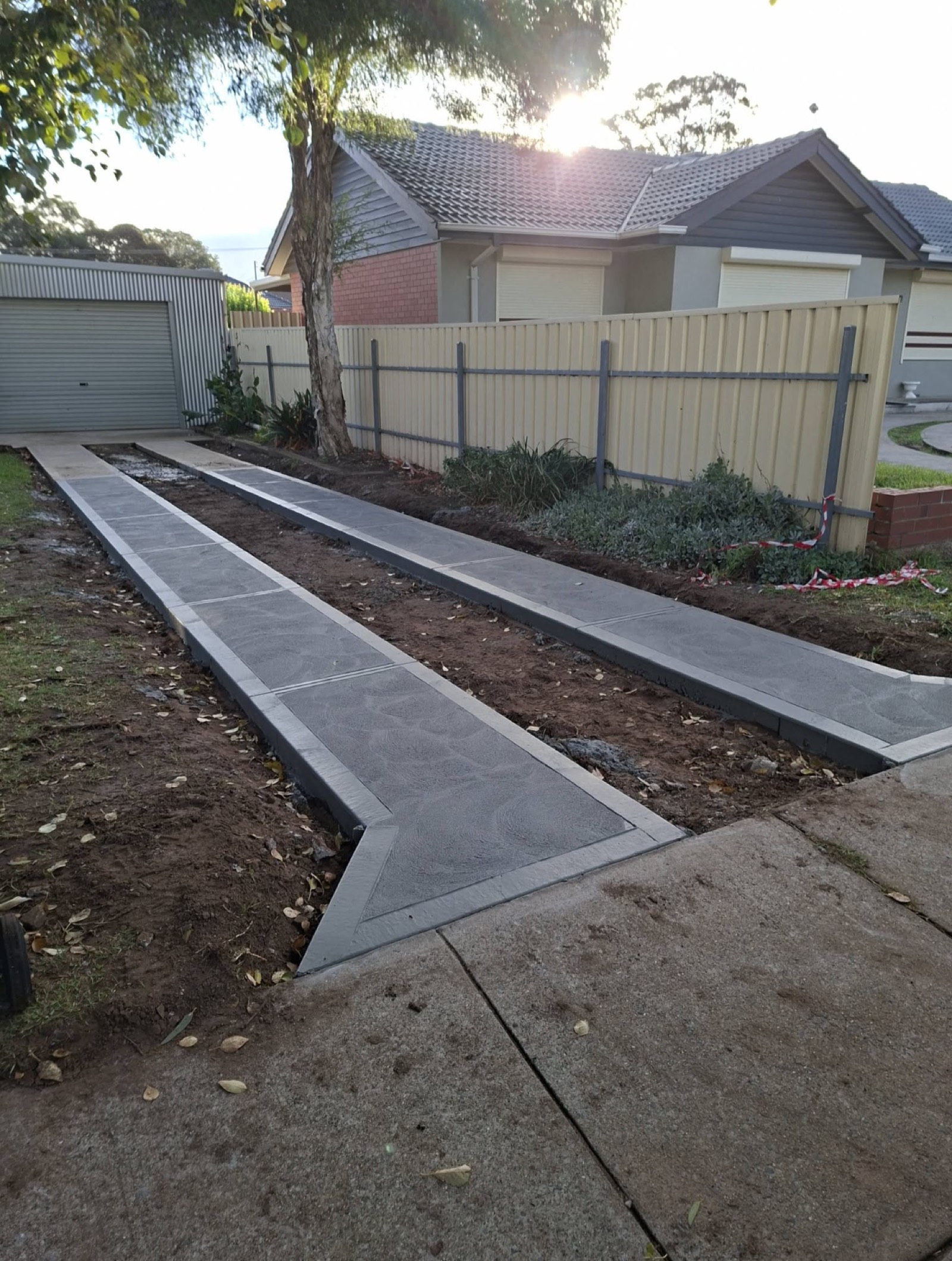 New charcoal concrete driveway strips with contrasting border